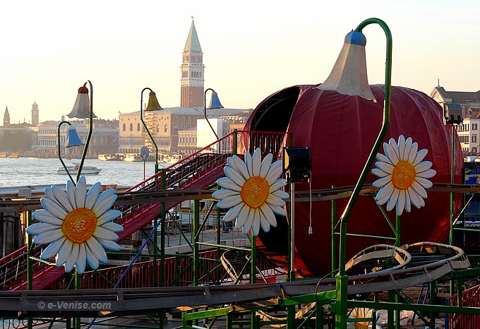 le campanile de saint marc à Venise derrière un manège forrain à la zucca